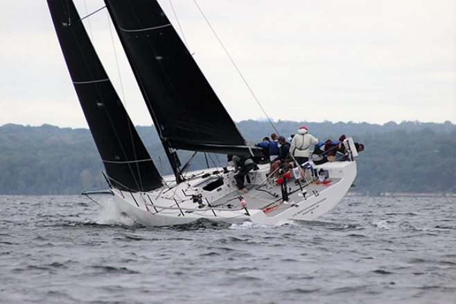Sharp turn on sail boat with black sails.
