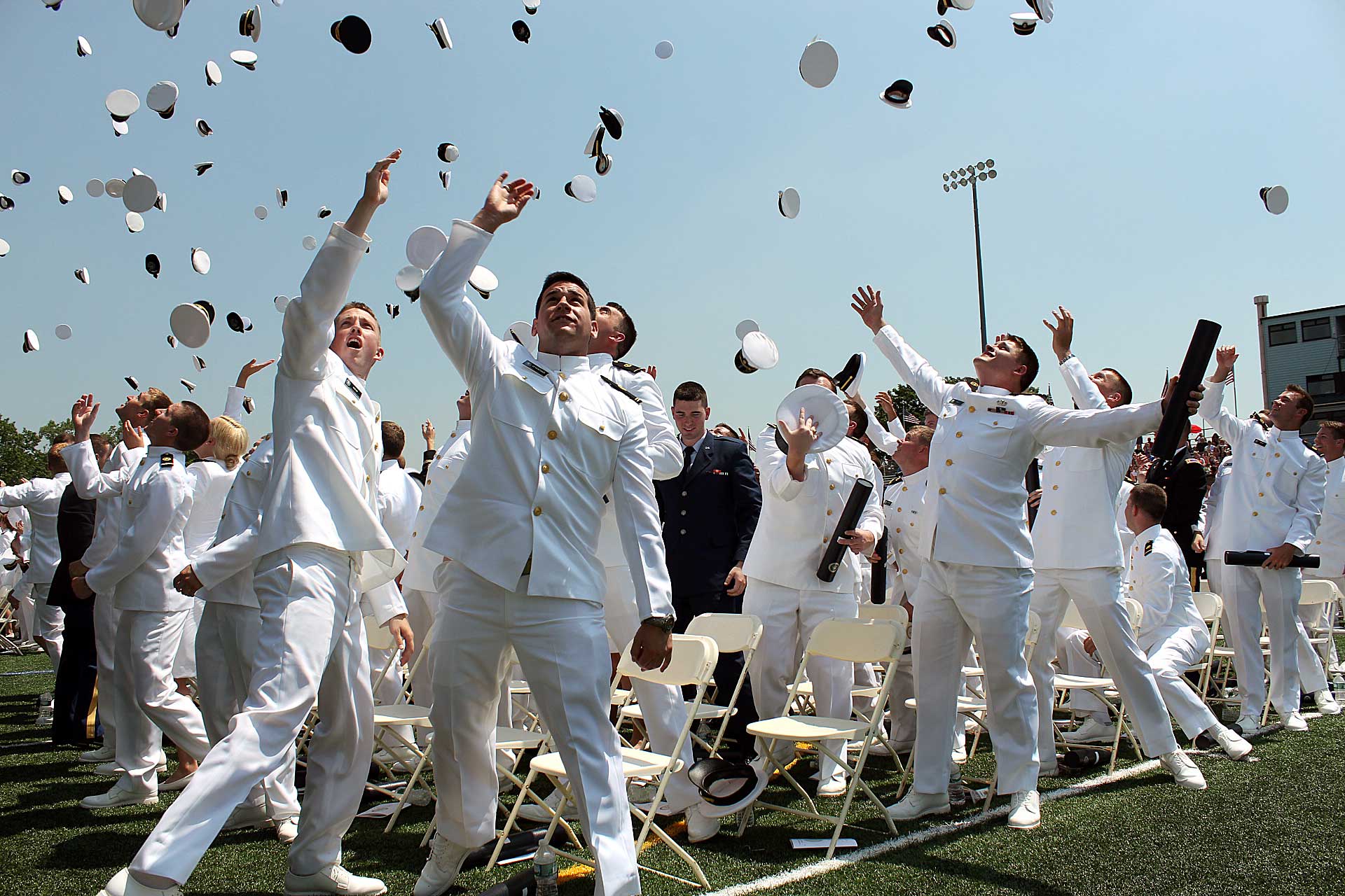 Midshipmen throwing hats at graduation