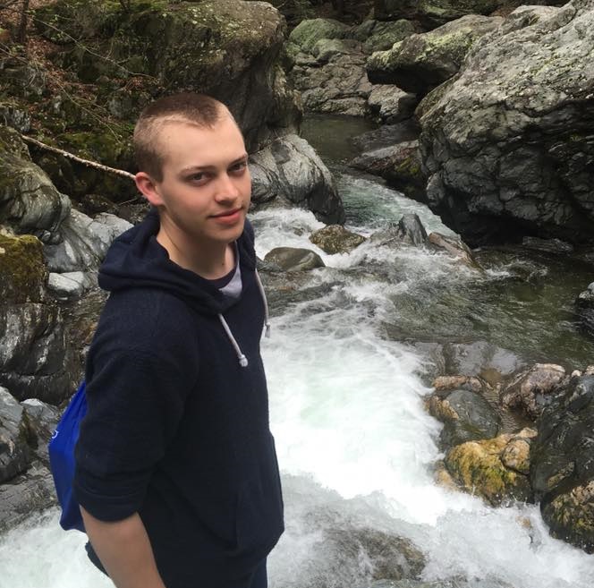 A boy by a creek.